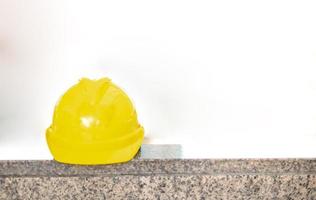 der gelbe harte schutzhelmhut für das sicherheitsprojekt des arbeiters als ingenieur oder arbeiter, der in der öffentlichen stadt auf den boden gelegt wird. foto