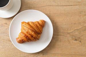 frisches Croissant auf weißer Platte foto