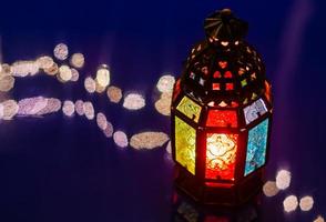 selektiver fokus der laterne auf blauem hintergrund mit reflexion von bokeh-licht für das muslimische fest des heiligen monats ramadan kareem. foto