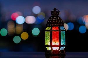 laterne mit nachthimmel und stadt bokeh heller hintergrund für das muslimische fest des heiligen monats ramadan kareem. foto