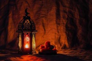 Schwarze Laterne und Dattelfrüchte auf dunklem Hintergrund für das muslimische Fest des heiligen Monats Ramadan Kareem. foto