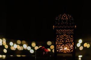 Laterne und Dattelfrüchte mit Bokeh-Licht im dunklen Hintergrund für das muslimische Fest des heiligen Monats Ramadan Kareem. foto