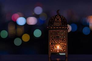 laterne mit nachthimmel und stadt bokeh heller hintergrund für das muslimische fest des heiligen monats ramadan kareem. foto