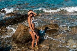 sexy junges Mädchen im Badeanzug am felsigen Strand foto