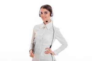 Horizontales Porträt eines jungen, fröhlichen Anrufbüroangestelltenmädchens mit Kopfhörern und Mikrofon, das in die Kamera schaut und isoliert auf weißem Hintergrund lächelt foto