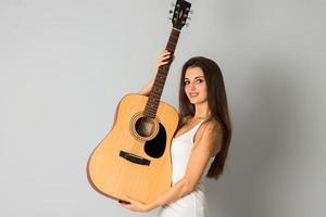 fröhliches junges Mädchen mit Gitarre in den Händen foto