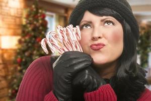 frau, die zuckerstangen in der weihnachtseinstellung hält foto