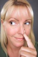 blonde Frau mit Finger in der Nase foto