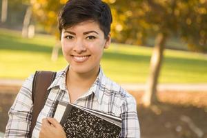 Porträt einer hübschen gemischtrassigen Studentin, die Bücher hält foto