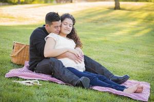 Schwangeres hispanisches Paar im Park im Freien foto