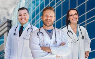 Gruppe gemischter männlicher und weiblicher Ärzte oder Krankenschwestern vor dem Krankenhausgebäude foto