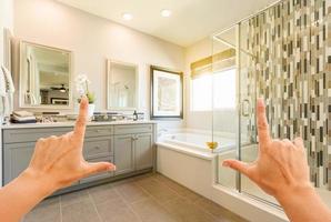 Hände, die das Interieur des benutzerdefinierten Master-Badezimmers einrahmen foto