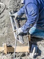 Poolbauer, der mit einer glatteren Stange auf nassem Beton arbeitet foto