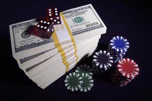 Hundert-Dollar-Scheine, rote Würfel und Pokerchips foto