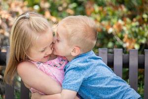 junge schwester und bruder haben spaß auf der bank im park foto