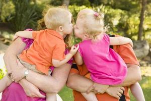 mama und papa halten küssende bruder und schwester kleinkinder foto