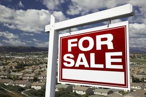 zum Verkauf stehendes Immobilienschild mit erhöhtem Blick auf die Wohngemeinschaft foto