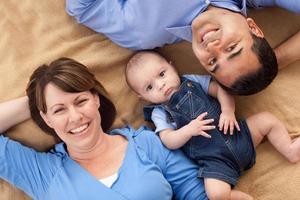 Mischlingsfamilie, die auf der Decke spielt foto