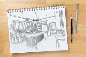 Skizzenblock auf dem Schreibtisch mit Zeichnung des individuellen Kücheninterieurs neben technischem Bleistift und Lineal foto