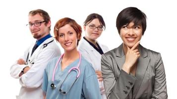 junge Mischlingsfrau mit Ärzten und Krankenschwestern dahinter foto