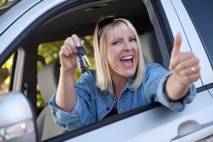 attraktive Frau im Neuwagen mit Schlüsseln foto