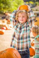 kleiner Junge, der in einer rustikalen Ranch am Pumpkin Patch steht. foto