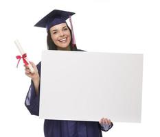 Absolventin in Mütze und Mantel mit leerem Schild, Diplom foto