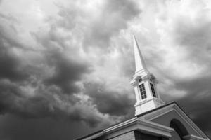 schwarz-weißer Kirchturmturm unter bedrohlichen stürmischen Gewitterwolken. foto