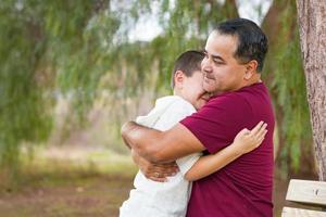 Hispanischer und kaukasischer Sohn und Vater gemischter Rassen, die sich im Park amüsieren foto