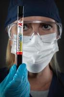 weibliche laborangestellte hält ein reagenzglas mit blut, das mit der coronavirus-covid-19-krankheit gekennzeichnet ist foto