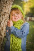 Porträt eines süßen jungen Mädchens mit grünem Schal und Hut foto