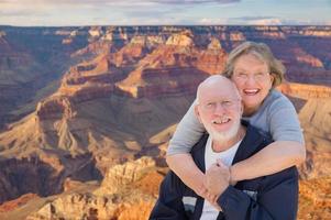 glückliches älteres paar, das am rand des grand canyon posiert foto