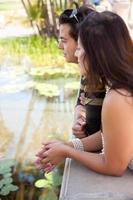 Attraktives hispanisches Paar mit Blick auf den Teich foto