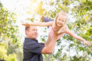 junger kaukasischer vater und tochter, die spaß im park haben foto