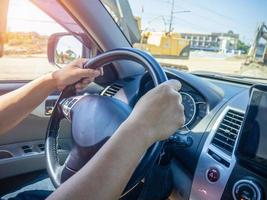 Die Hand eines Mannes hielt das Lenkrad eines Autos, um zu lenken, während das Auto wegfuhr. Konzeption und Leitung der Geschäftstätigkeit nach Plan. Richtungssteuerungskonzept. foto