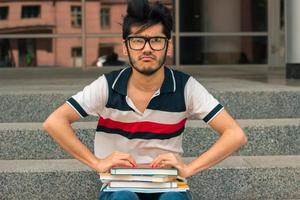 ein junger hübscher Student in Gläsern mit Büchern foto