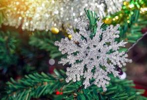 funkelnde weiße schneeflocken schmücken den weihnachtsbaum, um sich jedes jahr auf die festliche weihnachtszeit vorzubereiten. weicher und selektiver Fokus. foto