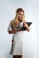 vertikales Foto der jungen sexy Krankenschwester mit Stethoskop und Tablet
