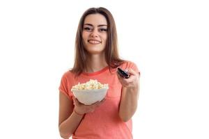 fröhliches Mädchen mit Popcorn vor dem Fernseher foto