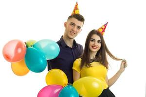 Fröhliches junges Paar mit Luftballons, das sich auf einer Geburtstagsfeier amüsiert foto