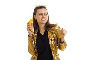 schönes Mädchen in rasender Goldjacke lacht und hält Bananen in den Händen foto