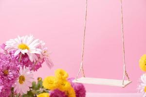 eine Schaukel mit Chrysanthemenblüten als Ständer für Ihr Kosmetikprodukt foto