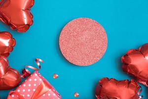 Podium oder Sockel und Geschenkbox mit roten Ballons in Herzform auf türkisfarbenem Hintergrund. Valentinstag Vorlage foto