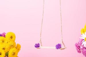 eine Schaukel mit Chrysanthemenblüten als Ständer für Ihr Kosmetikprodukt foto