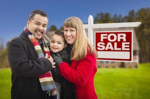 gemischte Rassenfamilie, Haus und zum Verkauf stehendes Immobilienschild foto