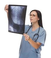 gemischtrassige ärztin oder krankenschwester, die röntgenaufnahmen auf weiß überprüft foto