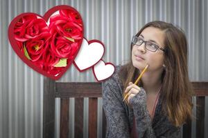 träumendes Mädchen neben schwebenden Herzen mit roten Rosen foto