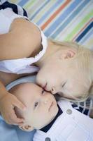 kleine Schwester, die neben ihrem kleinen Bruder auf der Decke liegt foto