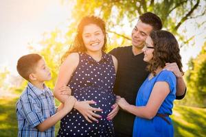 hispanisches schwangeres Familienporträt im Freien foto