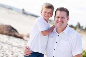 süßer Sohn mit seinem hübschen Vater am Strand foto